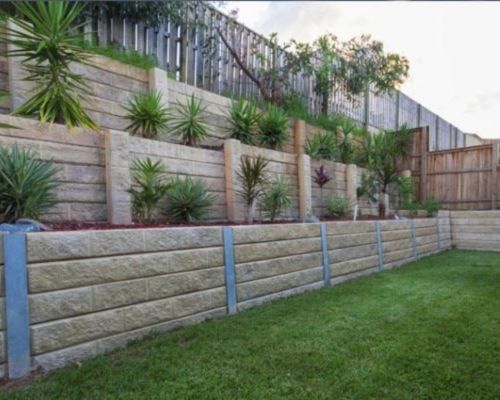 Structural retaining wall supporting sloped land